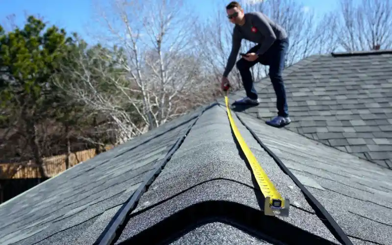 man on roof measuring ridge